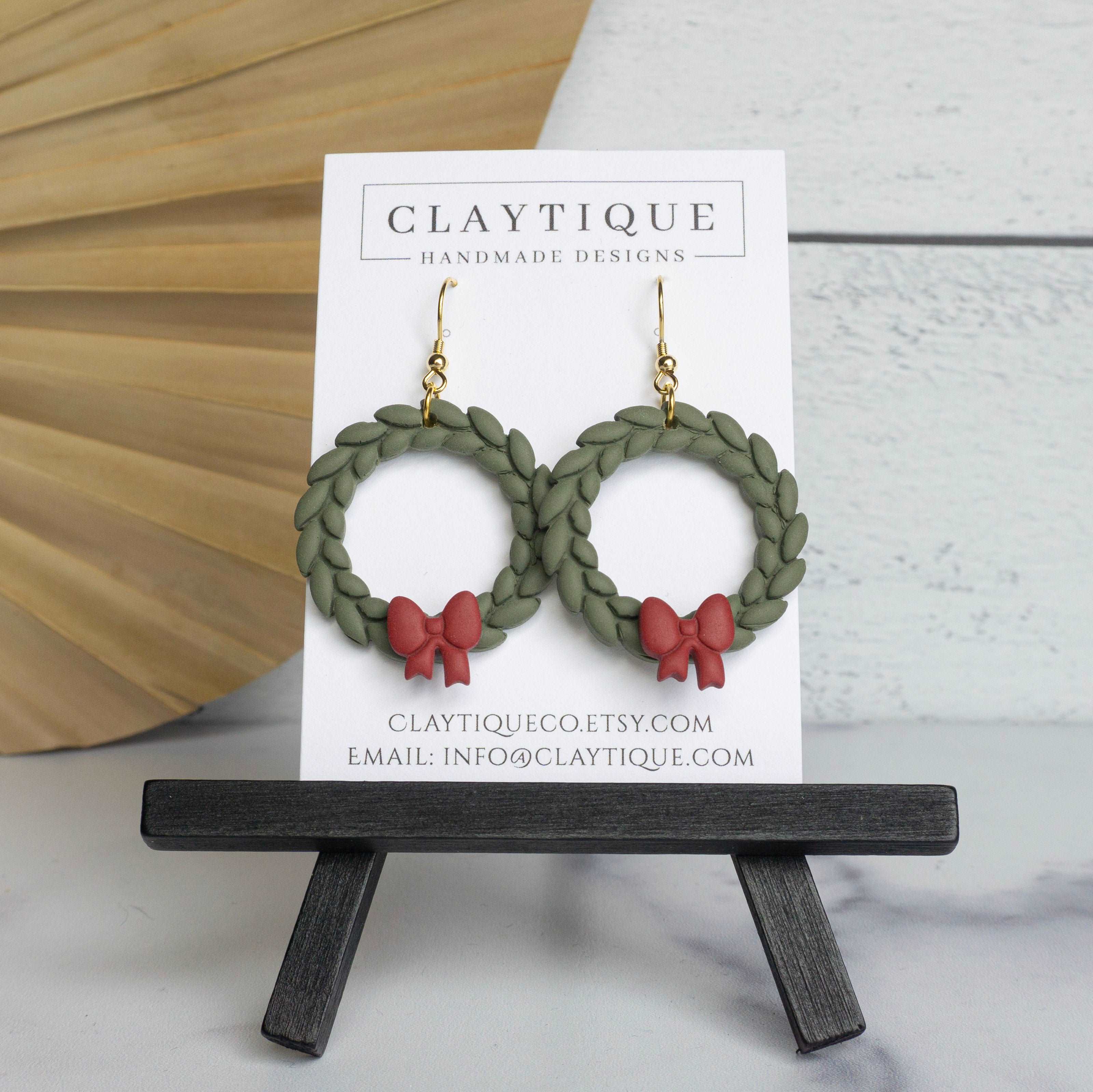 Handmade Polymer Clay Earrings featuring green thin wreath with red bow and Gold plated Stainless Steel (316-L) french ear wires. Nickel free/hypoallergenic 